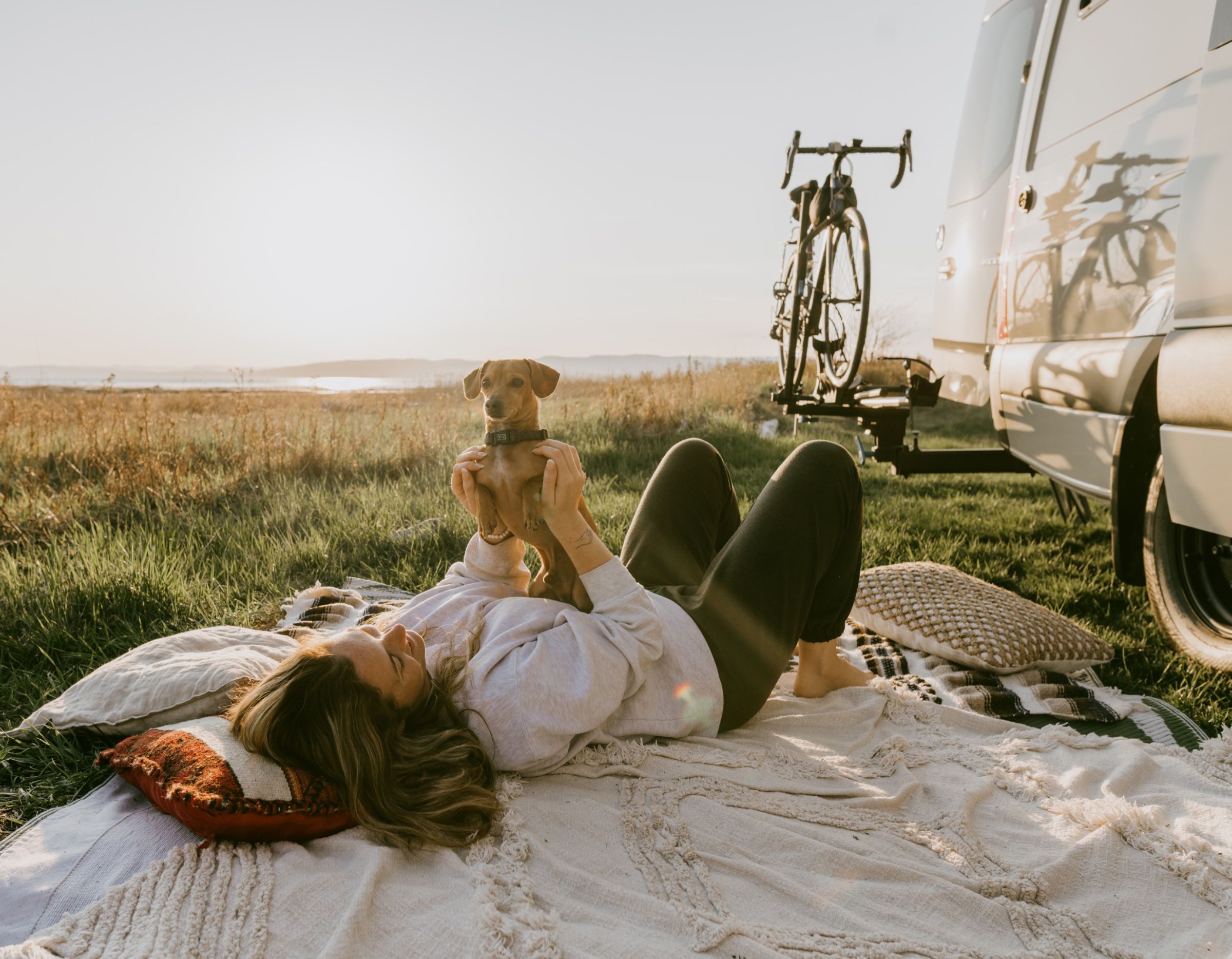 Détente au coucher du soleil devant le van avec son chien